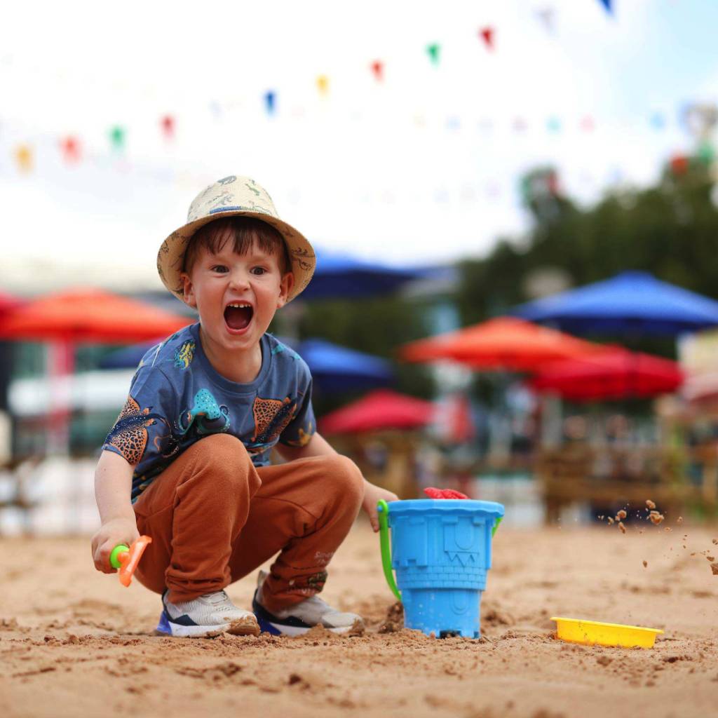 A small boy playing with a bucket and spade