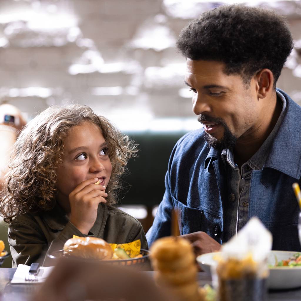 An adult and child eating burgers